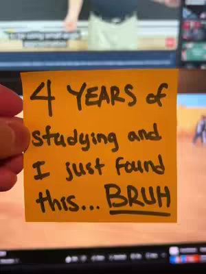 A hand holds a yellow sticky note with black marker text. The note says, '4 YEARS of studying and I just found this... BRUH'. The background is a blurry interior scene with computer screens visible.