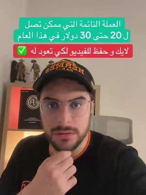 A man with glasses and a black cap is centered in the frame, his head and shoulders visible. He is looking directly at the camera with a neutral expression. Behind him are shelves with items displayed, suggesting a home or office setting. Overlayed are two green rectangular text boxes with white Arabic text, discussing a cryptocurrency coin's potential value, and below a red text box with white Arabic text, including a check mark, implying agreement or promotion of the crypto information.