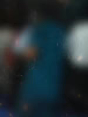A blurred abstract image dominated by shades of blue, black, and white. The composition is heavily blurred, creating a sense of depth and indistinct forms. There are brighter, white areas that suggest highlights or areas of strong light contrasted against the darker background. The overall impression is atmospheric and non-representational.