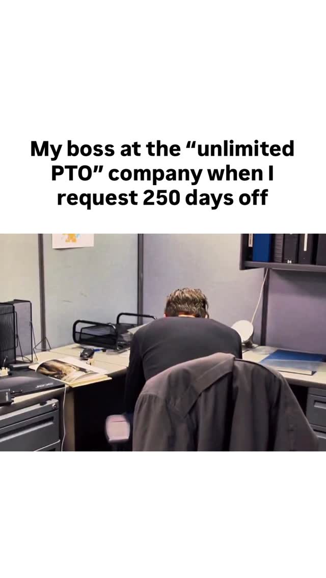 The image is a meme template featuring text overlayed on an office setting. The background shows a man seated at his desk from behind. The man is wearing a black shirt and looking at a computer monitor. The text overlayed on the image reads, "My boss at the unlimited PTO company when I request 250 days off."
