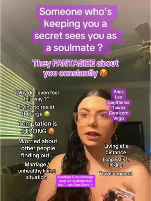 A woman with glasses and dark hair is centered in the frame, looking directly at the camera. Text overlays are arranged around her, including framed text boxes with phrases like 'Someone who's keeping you a secret sees you as a soulmate?' and additional phrases such as 'Why do I even feel this way?' and 'Temptation is STRONG.' The background is a blurred interior with window blinds and a glimpse of a ceiling fan. The color tones are muted, with the text in vibrant hues. The overall composition suggests a personalized, conversational style.