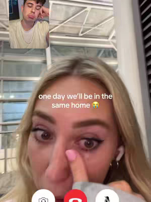 The cover image shows a woman in a video call and a male is on the screen; she is touching one eye with a pink-painted fingernail. Text  "one day we'll be in the same home " overlaid on the image.