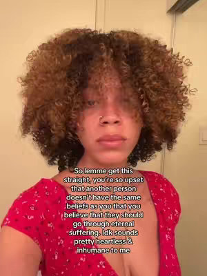 The cover image features a person with curly brown hair, a nose ring, and wearing a red dress. Text overlaid on the image discusses religious beliefs and eternal suffering.