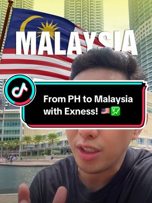 A selfie-style video cover featuring a young man in front of a blurred background of a city skyline and the Petronas Twin Towers. The image is overlaid with text and graphics, including the flag of Malaysia. The man is looking towards the camera, and a banner with text is in front of him. The colors are vibrant, with a focus on blue, red, and white from the flag.