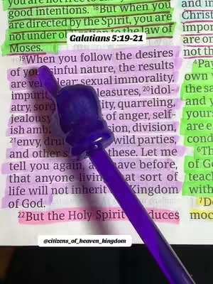 A close-up image shows a page from a book, possibly a Bible, with highlighted text and a purple pen pointing towards the text. The page is open to a passage with text highlighted in green and light purple. A purple pen is placed diagonally across the page, the tip of the pen is touching the text.