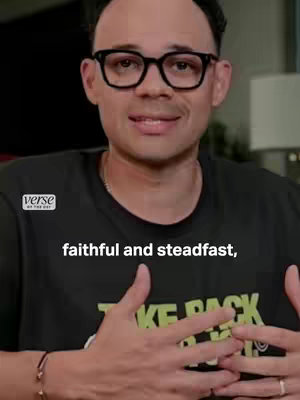 A medium shot of a man with glasses, wearing a black t-shirt, in a well-lit indoor setting, with text overlayed on the image.