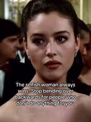 A medium shot features a woman looking slightly to the side with a serious expression. She has dark hair pulled back, and is wearing earrings. Text overlayed includes the message. Behind her are out-of-focus figures.