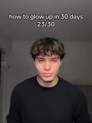 A young man with dark hair is centered in the frame. Above him is text that reads 'how to glow up in 30 days 23/30'. The man is wearing a black sweater. The background is a simple, neutral wall.