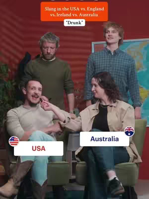 The cover image has a group of four people in a room featuring a dark red wall background and wooden floors. There is a world map on the wall. Four individuals are present, with two people seated in green chairs and two standing behind them. The image uses a variety of colors.