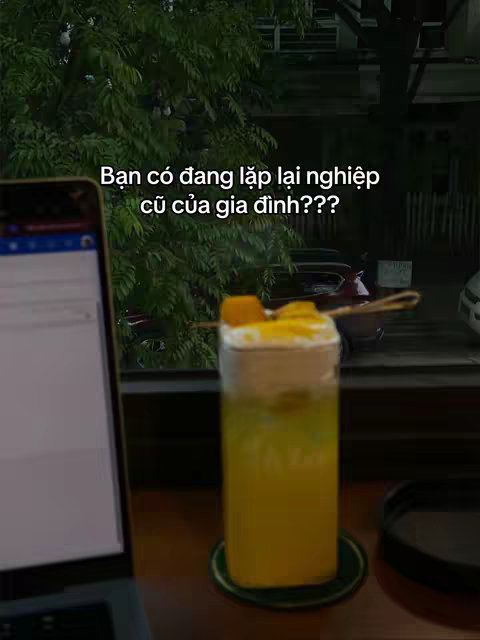 The cover image shows a laptop on a wooden surface, with a glass of yellow-colored beverage on a green coaster, beside it. The background reveals an outdoor scene with green foliage and a building.