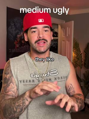 A man in a red baseball cap and gray tank top is speaking. The background includes a room with a poster and a door.