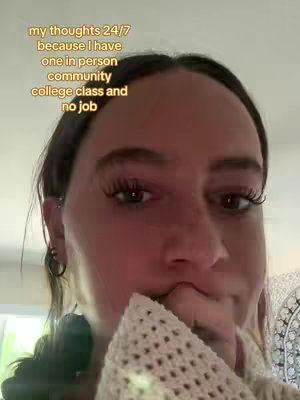 A close-up shot of a woman's face. Text overlays the image, while the woman holds part of a knit sweater to her mouth, looking to the side.
