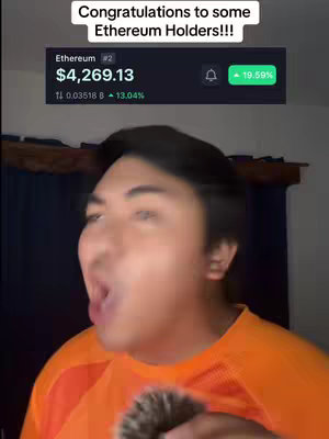 A man with dark hair and an open mouth, wearing an orange shirt. Above him, a screenshot displays the Ethereum price with an increase of 19.59%. The background is a plain wall.