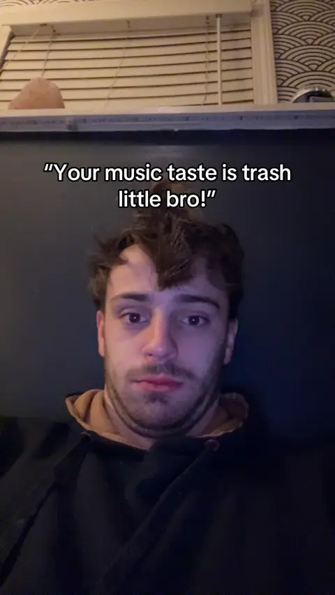 A man with dark hair stares directly at the camera with a slightly annoyed expression. Text overlays his head.