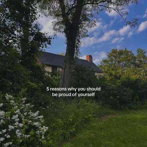 A scenic outdoor image featuring a house nestled amongst green trees and plants under a blue sky with clouds, there is text overlaid that says '5 reasons why you should be proud of yourself'.
