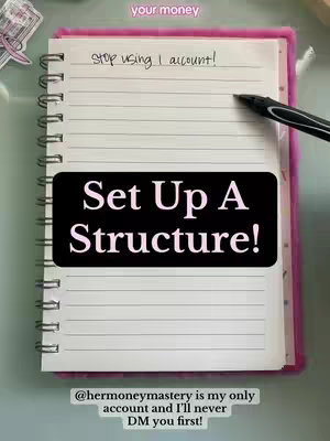 A notebook is open to a blank page, with the text \"Set Up A Structure!\" written in bold on a black box. There's a pink border on the notebook, and a pen is next to the text. The background is a light bluish-green surface, with a small piece of paper and a sticker.