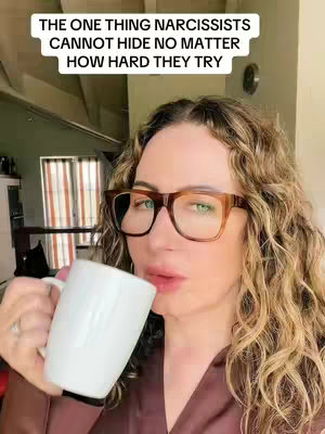 The cover image is a medium shot featuring a woman with curly, light brown hair, wearing large, dark-framed glasses. She's holding a white mug up to her lips, appearing to take a sip. She's wearing a brown robe or top. The background softly reveals a domestic interior with a window and some out-of-focus furnishings. The image is lit warmly, suggesting a relaxed setting.