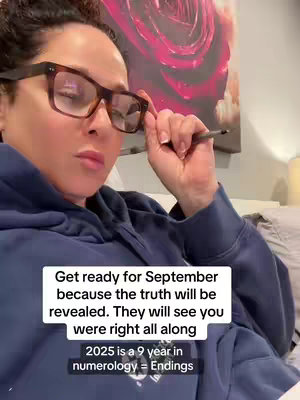 A person is looking down with a slightly concerned expression, taking a pen out of their glasses. Text overlays provide a spiritual insight and numerology dating the year 2025.