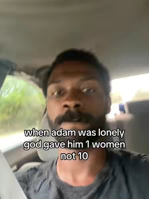 A selfie-style shot from inside a vehicle. The primary focus is on a Black man with a well-groomed beard and mustache. He is looking toward the camera. Text overlay is added below, in a white font, centered on the screen against the backdrop of the vehicle’s interior.