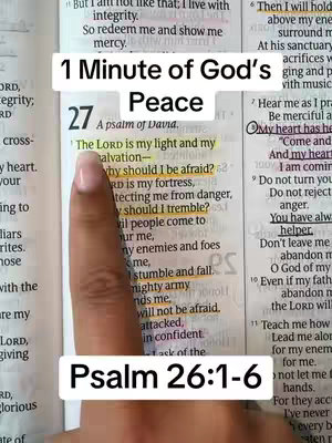 The image shows an open page of a Bible with text highlighted and a finger pointing to a highlighted verse.