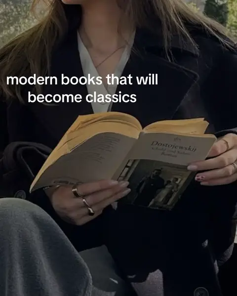 A person is seated outdoors wearing a black coat, reading a book with an open page showing text and an illustration. The scene is softly lit, with a focus on the book and the person's hands, creating a relaxed atmosphere.