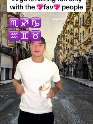 An Asian man is walking down a street towards the camera, with a cityscape as the background. Above the man, there are purple zodiac sign icons, and above them is pink text that reads 'Virgo is having fun only with the fav people'.