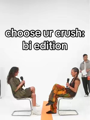 The cover image is a brightly lit shot featuring two women sitting on chairs facing each other, each holding a microphone. They are positioned on opposite sides of a dividing line on the floor, perhaps for emphasis or to indicate different viewpoints or to be 'on set'. Above them is white text on a black background, and a man with a paper stands behind and to the right, giving the scene a staged, interview setting.