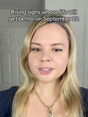 A medium shot features a woman with long blonde hair, facing the camera and speaking. The background is a plain white wall featuring doors.