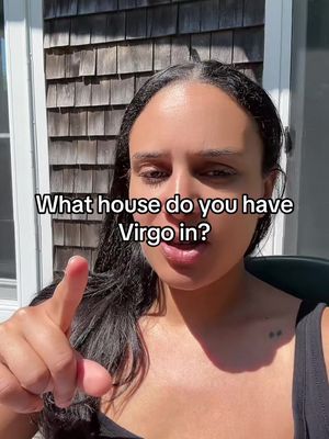 A woman with long dark hair points towards the viewer against a backdrop of a wooden wall. Text overlayed on the image asks, "What house do you have Virgo in?"