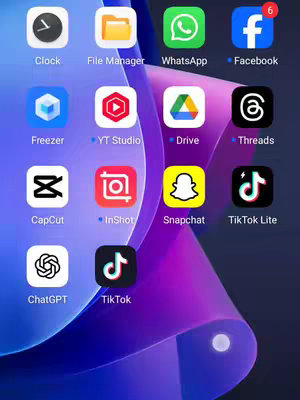 The image displays a mobile phone's home screen. Various app icons are arranged in a grid formation. Overlaid on a purple gradient background are multiple app icons, including icons for Clock, File Manager, WhatsApp, Facebook, Freezer, YouTube Studio, Drive, Threads, CapCut, InShot, Snapchat, TikTok Lite, ChatGPT, and TikTok. The arrangement is somewhat disorganized, indicating a casual display of the phone's apps.
