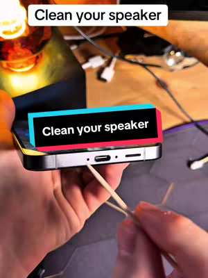 The cover image shows a hand holding a smartphone, with the speaker area directed towards the viewer. A q-tip touches the speaker. The image layout includes instructional text overlayed near the speaker.