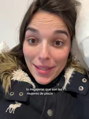 The cover image features a close-up shot of a woman looking directly at the camera. She has brown hair and is wearing a dark jacket with fur trim around the hood. The background is a light, solid color, and text is overlaid at the bottom. She has brown eyes and a slight smile.