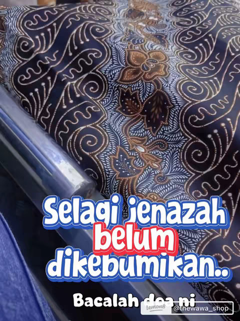 The image features a close-up of a patterned fabric, likely covering a body, given the context of the text overlay. The fabric has a dark navy blue background with intricate patterns in shades of brown and white. The patterns appear to be floral and swirling designs. Overlaid on this are large, colorful text blocks in white, blue, and red, providing information or a message. The overall composition presents a somber yet informative tone.