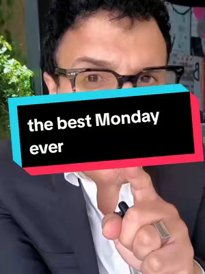 A man wearing glasses and a suit points towards the camera, with an overlay containing the text 'the best Monday ever'. The background is blurred but appears to be outdoors.