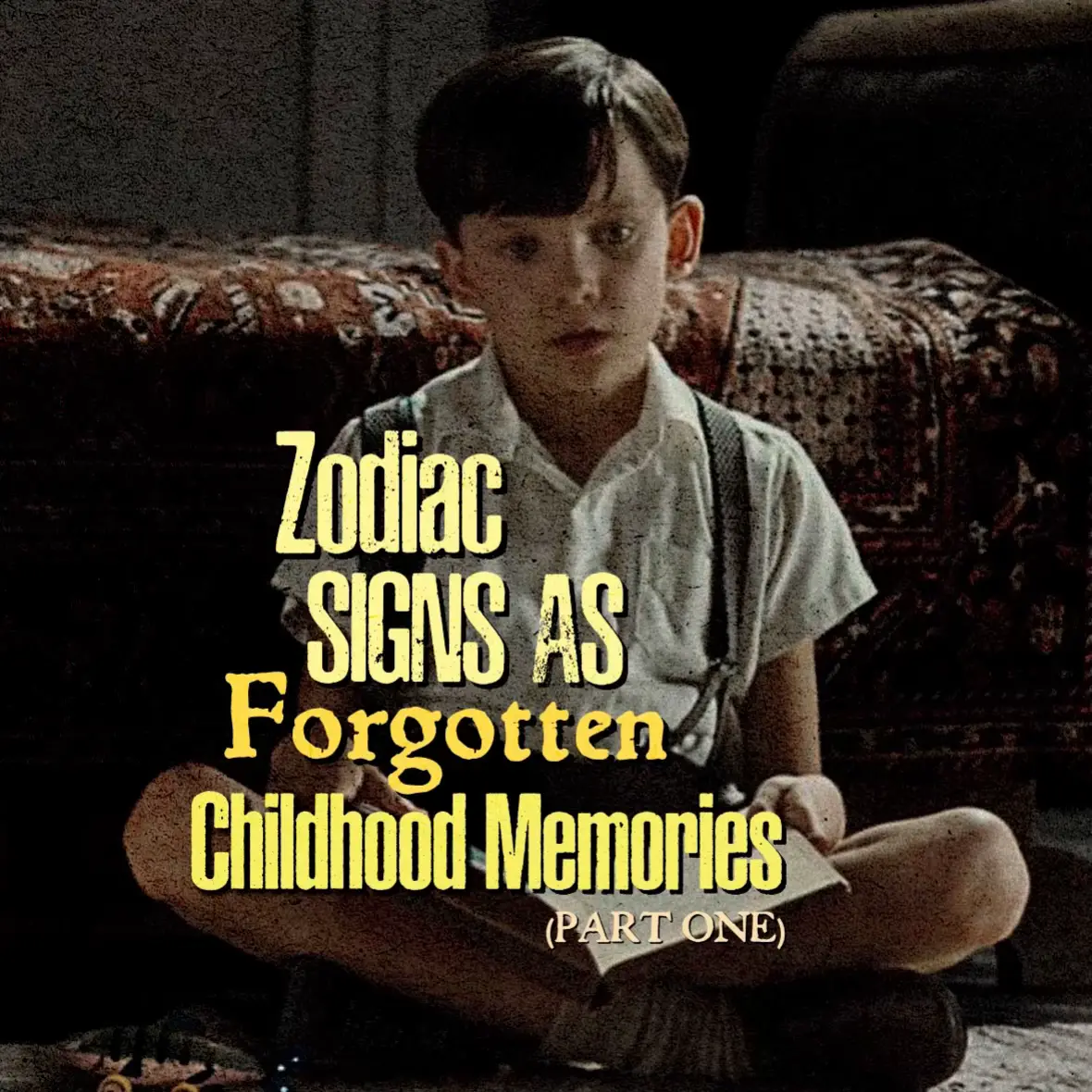 A young boy sits cross-legged, holding a paper, with text overlays. He wears a white collared shirt, suspenders, and is positioned in front of a patterned blanket. Text in a yellow font reads, "ZODIAC SIGNS AS Forgotten Childhood Memories" with "(PART ONE)" below.