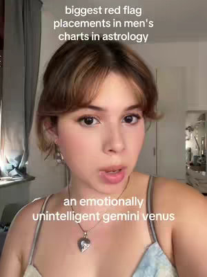 A woman with light skin and brown hair is looking directly at the camera. The image includes text overlays stating 'biggest red flag placements in men's charts in astrology' and 'an emotionally unintelligent gemini venus' The woman has a neutral expression and is wearing a tank top with a pendant necklace.