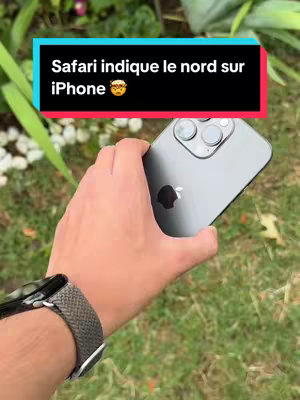 A hand holding a gray iPhone in front of a green lawn. A black box with white text overlayed on top.