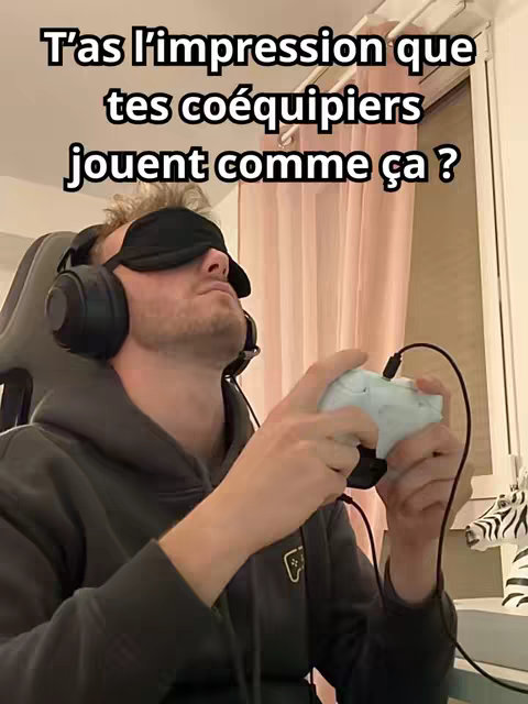 A man wearing a blindfold and headphones sits in a gaming chair, holding a white controller. A text overlay asks if the viewer's teammates play like this, referencing a common issue in gaming. The background includes a window with pink curtains and a decorative zebra statue.