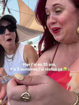 The cover image is an indoor, candid shot of two women. On the right there's a person with red hair. The background includes a white shaded roof. The woman on the left is slightly out of focus, wearing sunglasses and a hat. The text overlay states "Y'a 15 ans, j'avais 20 ans Dans 15 ans, j'ai 50 ans 😳 LA VIE COUUUUURT SI VIIIIIIITE". The image is well-lit.