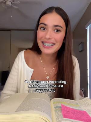 A young woman with long brown hair and braces is smiling directly at the camera. Text overlays the image. She is wearing a white cardigan over a floral print top and a necklace. The background shows a room with a door and a window. An open book lies in her lap.