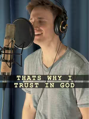 The cover image features a man singing into a microphone. He is wearing headphones and a grey t-shirt. Text overlayed on the image states 'THAT'S WHY I TRUST IN GOD'. The background is a blurred blue.