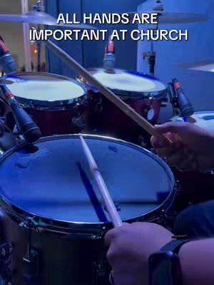 The cover image shows a close-up of a drum set being played, with a pair of hands holding drumsticks poised above a drum. The drums are illuminated with a blue light, creating a cool and vibrant atmosphere. Microphones are visible near the drums, suggesting a recording or performance setting.