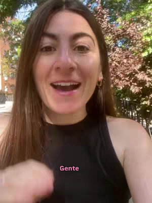 A woman with long brown hair and an open mouth looks directly at the camera. The background includes trees and foliage. The text overlay says "Gente".