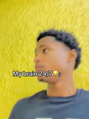A young man is shown with his head and upper body facing the left side of the frame. His skin is light brown. On his head, his hair is closely cropped, and he has a slight shadow of stubble along the jawline. The background behind him is a bright, textured, yellow surface, providing a strong contrast to the man. The man wears a dark blue t-shirt. A text overlay appears on the left side of the image.