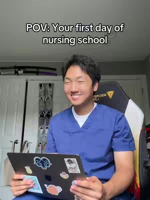 A smiling Asian man in blue scrubs holds a laptop with stickers, sitting in a gaming chair. Above him is text overlayed, 'POV: Your first day of nursing school.' The background has a wall, and a set of swords on the wall.