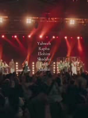 The image captures a live performance with a crowd, a stage, and bright red lighting. In the forefront, a large crowd is visible with their backs facing the camera. On the stage, a band and singers are performing with a spotlight on them. The background of the stage has multiple lights. The colors are mostly red, with some lighter hues for the performers and the text overlay. The layout is a typical concert shot, emphasizing the energy and emotion of the event.