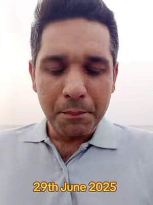 A man with closed eyes in a light blue shirt is centered in the frame, with a light-colored sky in the background. Text in a yellow box at the bottom of the image reads '29th June 2025'.
