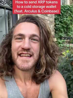 A close-up image of a man with long, wavy brown hair and a beard. He is wearing a gray tank top and smiling directly at the camera. Above him is a red banner with white text that reads, "How to send XRP tokens to a cold storage wallet (feat. Arculus & Coinbase)". The background includes a brick wall, greenery, and a glimpse of a door or window frame.