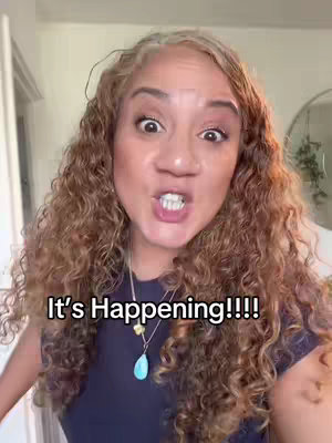 A woman with curly brown hair and a navy blue shirt, stares intensely at the camera with wide eyes and an open mouth. The text overlay reads 'It's Happening!!!!'.