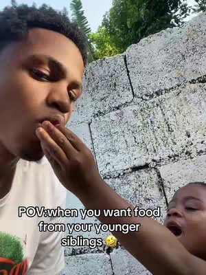 A man is shown from the chest up, with part of his hand reaching out to bring food to the mouth. To the right, a small child on a blurred background is visible.